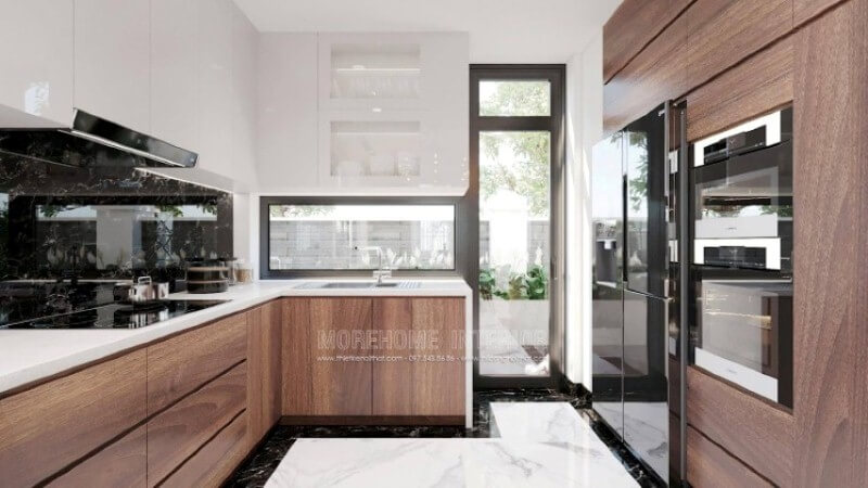 Là một trong những xu hướng trang trí nội thất ấn tượng trong những năm tới, bố trí phòng bếp hiện đại tôn lên vẻ đẹp mộc mạc nhưng không kém phần sang trọng của gỗ điển hình là gỗ óc chó veneer . Loại gỗ rất được ưa chuộng trong các siêu xe bởi vẻ đẹp ấn tượng từ vân, màu gỗ. Như trong ý tưởng thiết kế phòng bếp tại biệt thự Vinhomes Imperia, sự hài hòa tôn lên nét đẹp giữa truyền thống và hiện đại, tủ bếp dưới gỗ óc chó veneer và tủ bếp trên acrylic trắng bóng. Tủ bếp gỗ công nghiệp